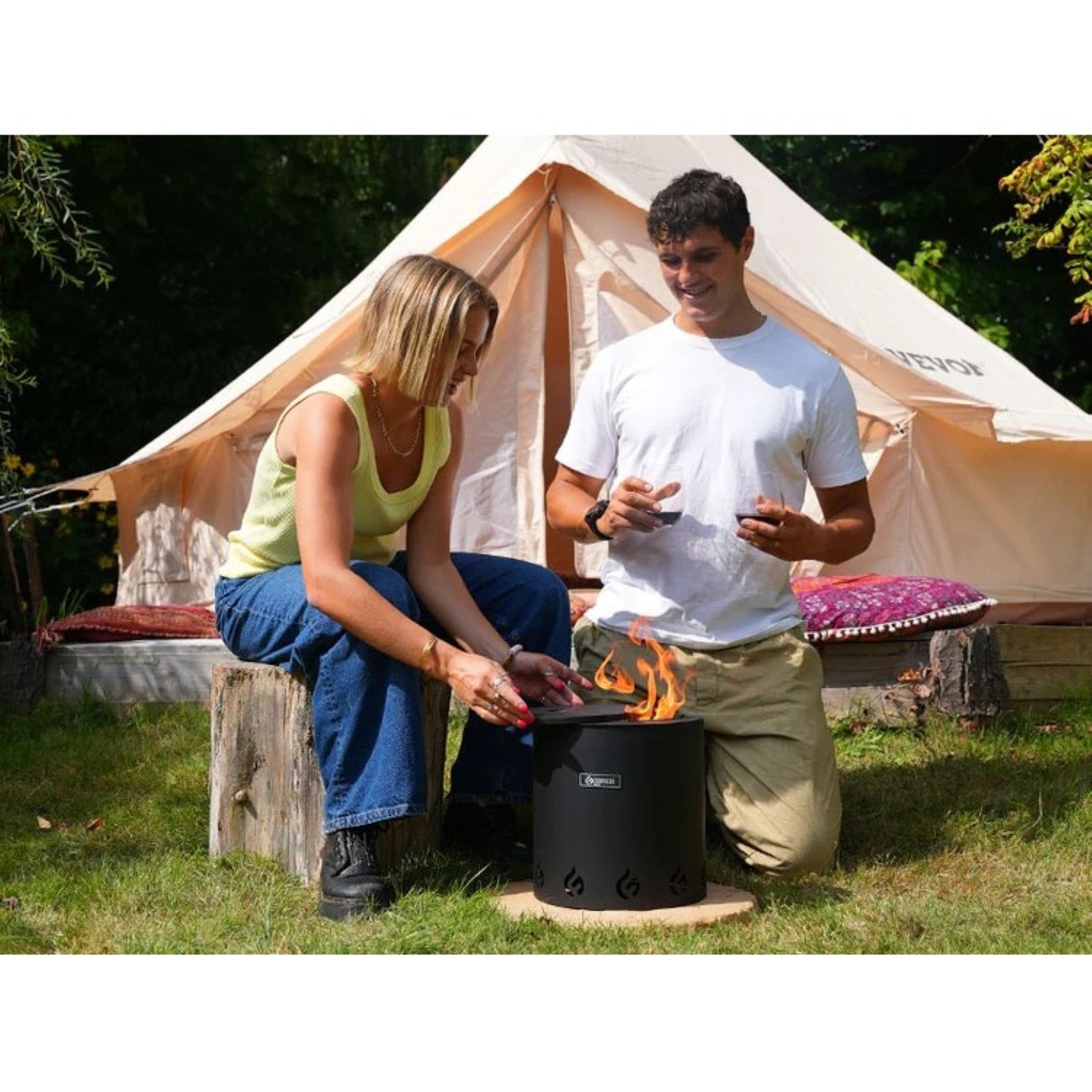 Two people camping outdoors with a portable stove.